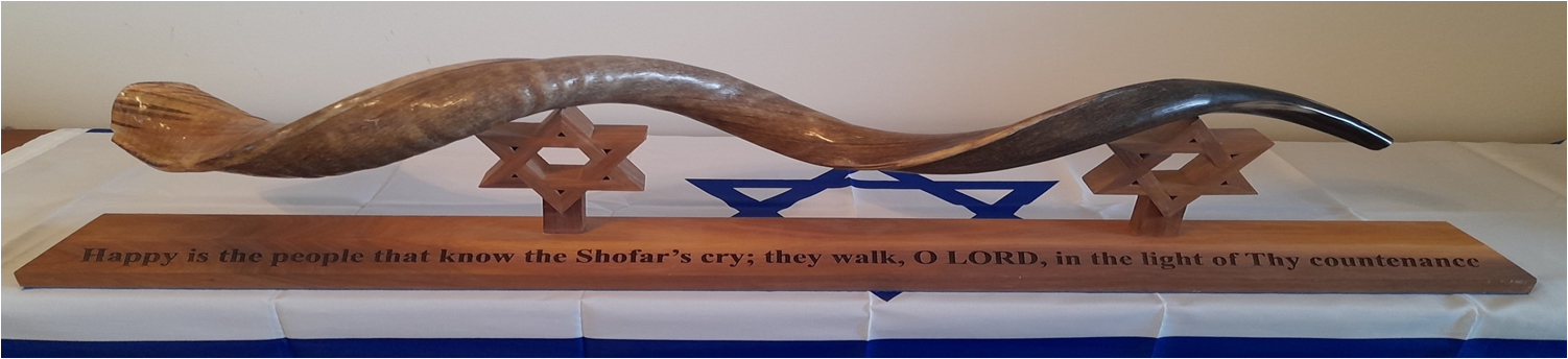 Shofar displayed above the inscription from Psalm 89:15